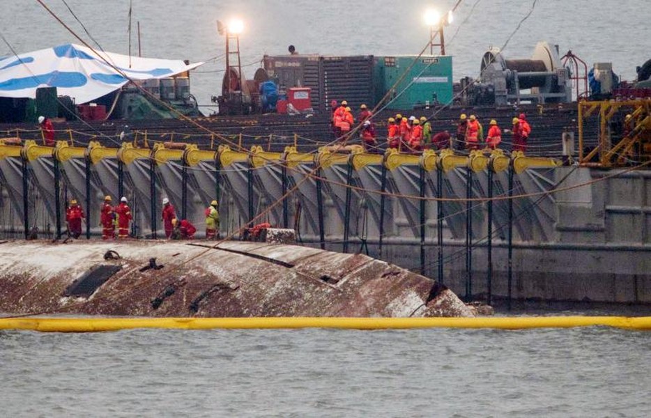 Bộ Thủy sản và Hải Dương Hàn Quốc hôm 23/3 trục vớt thành công chiếc  phà Sewol chìm từ độ sâu 40 mét dưới đáy biển phía tây nam đảo Jindo. Ngày 16/4/2014, phà này đã bị chìm khi đang chở 476 hành khách từ Incheon tới đảo Jeju, khiến hơn 300 người chết, trong đó có 250 em học sinh. Ảnh Reuters